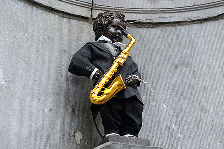 photo du Manneken Pis avec un saxophone et un beau costume