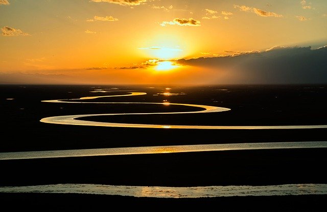 méandre d'une rivière et vue sur un coucher de soleil d'une belle couleur jaune