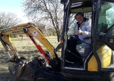 Didier au volant de la mini-pelle, pour préparer les trous de plantation